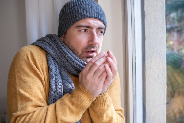 man feeling cold inside the house due to uneven temperature