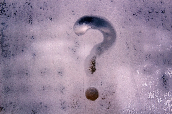 question mark on frosted glass window depicting FAQs about energy-efficient HVAC