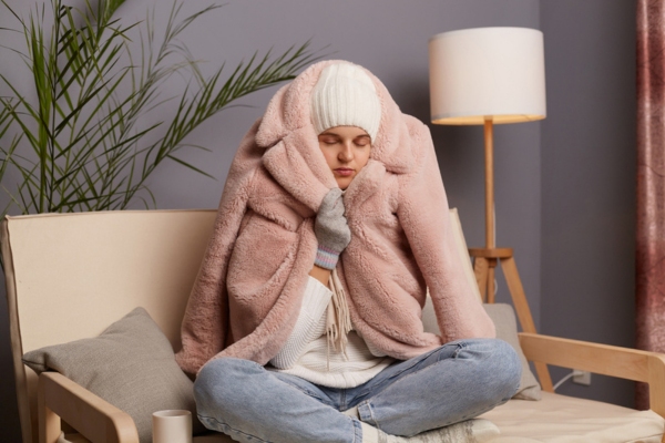 woman feeling cold indoors due to malfunctioning furnace