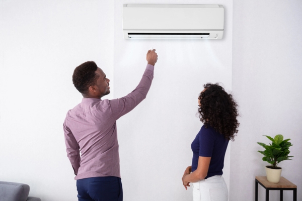 couple adjusting ductless heating system temperature at home