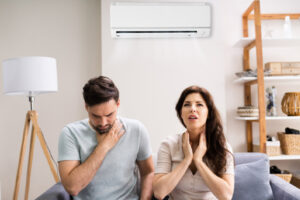 homeowners with air conditioner depicting poor indoor air quality