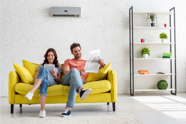 couple lounging in the living room and staying cool with a ductless air conditioner depicting summertime