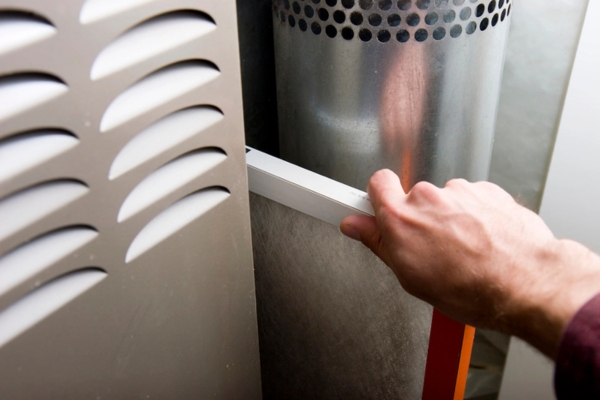 homeowner replacing furnace filter