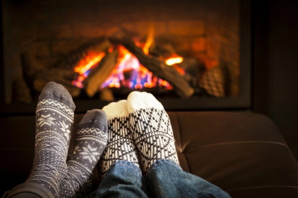 feet wearing socks by the fireplace depicting winter and heating efficiency