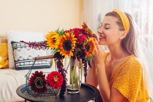 woman smelling fresh flowers depicting springtime and energy-savings for spring