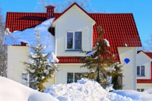 house with a red roof after a snow storm