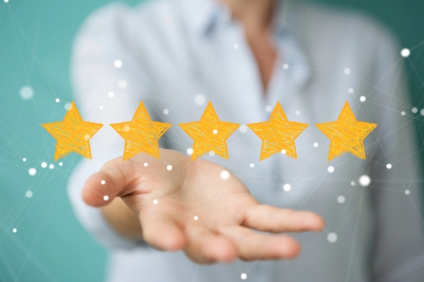 cropped view of a woman's hand holding up 5 hand drawn stars depicting AFUE rating