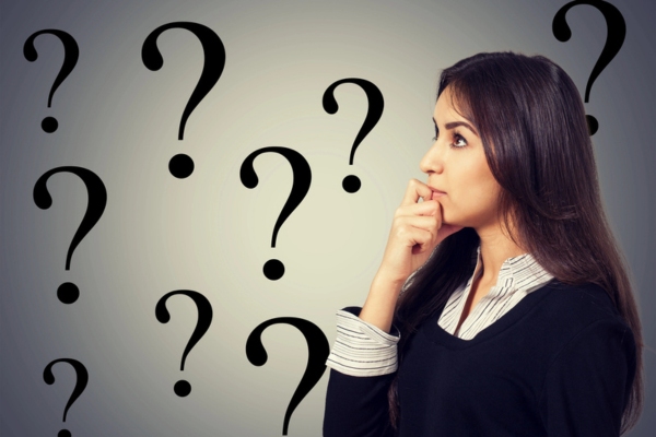 woman looking sideways with question marks in the background depicting FAQs about oil furnace