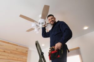 repairman servicing ceiling fan with lights